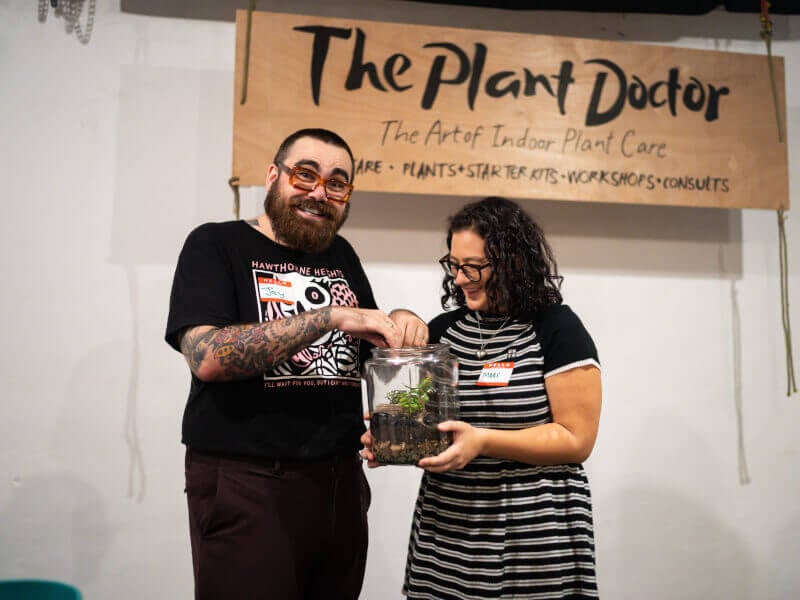 A couple hold their handmade terrarium